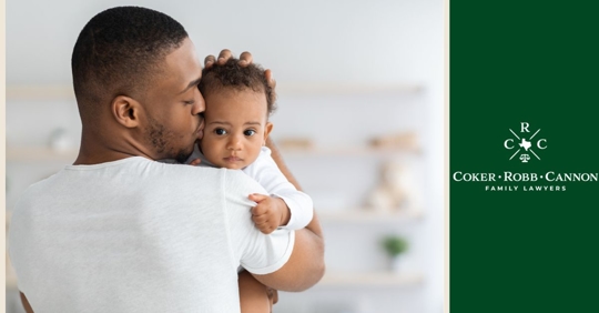 Man kissing the cheek of a newborn